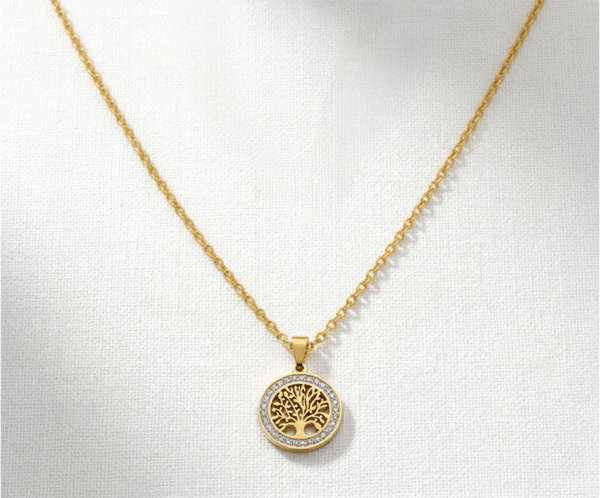 El Collar Árbol Crystal Circle Golden es una pieza deslumbrante que combina misticismo y lujo. Presenta un medallón con el Árbol de la Vida, rodeado por un círculo de cristales brillantes que capturan la luz. Fabricado en acero quirúrgico con acabado en oro PVD, es una joya resistente y sofisticada, cargada de profundo significado espiritual.
