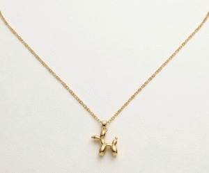 El Collar Balloon Dog Gold Pequeño es una pieza de diseño vibrante y sofisticada que rinde homenaje al arte pop moderno. Con un colgante de silueta icónica y acabado pulido espejo, esta joya aporta un toque creativo y lúdico. Fabricada en acero quirúrgico con recubrimiento de oro PVD, garantiza un brillo duradero y una elegancia inalterable.
