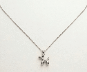 El Collar Balloon Dog Silver Pequeño es una joya minimalista inspirada en el arte pop contemporáneo. Su delicado colgante presenta una silueta icónica con un acabado pulido de alto brillo que captura la luz con elegancia. Fabricado en acero quirúrgico, es una pieza resistente, moderna y versátil, ideal para añadir un toque creativo al estilo diario.