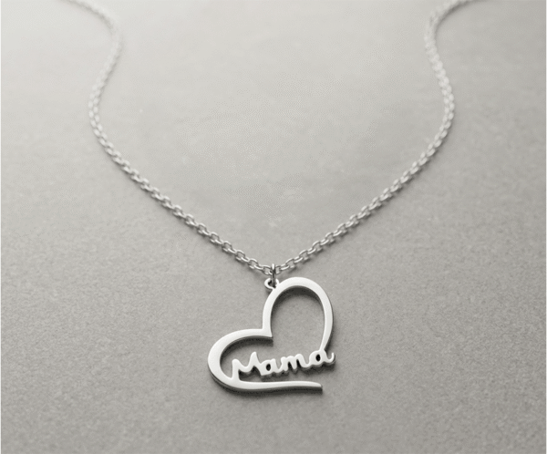 Este collar plateado es un tributo a la maternidad. Presenta un diseño de corazón calado que envuelve delicadamente la palabra "Mama" en trazos suaves y elegantes. Fabricado en acero inoxidable de alta calidad, combina la durabilidad con un estilo contemporáneo y minimalista. Es la joya perfecta para honrar ese vínculo incondicional con elegancia atemporal y brillo permanente.