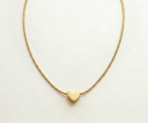 El Collar Corazón Minimal Golden es la máxima expresión de la elegancia discreta y el romance moderno. Presenta un dije de corazón sólido con acabado pulido espejo que se desliza sobre una delicada cadena dorada. Fabricado en acero quirúrgico con recubrimiento PVD, es una pieza atemporal, resistente y sofisticada, perfecta para cualquier ocasión.