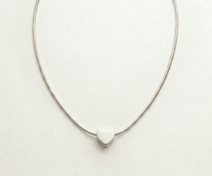 El Collar Corazón Minimal Silver es la máxima expresión de la elegancia discreta. Presenta un dije de corazón sólido y pulido que se desliza delicadamente sobre una cadena tipo serpiente de brillo sedoso. Fabricado en acero quirúrgico, es una pieza atemporal y versátil, diseñada para simbolizar el amor puro con un estilo moderno y sofisticado.