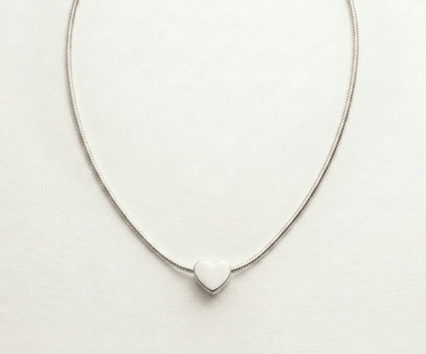 El Collar Corazón Minimal Silver es la máxima expresión de la elegancia discreta. Presenta un dije de corazón sólido y pulido que se desliza delicadamente sobre una cadena tipo serpiente de brillo sedoso. Fabricado en acero quirúrgico, es una pieza atemporal y versátil, diseñada para simbolizar el amor puro con un estilo moderno y sofisticado.
