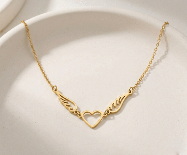 Este collar dorado es una expresión sublime de amor y libertad. Su diseño presenta un delicado corazón central unido a dos alas caladas con trazos fluidos y elegantes. Fabricado en acero inoxidable de alta calidad con acabado en oro PVD, combina durabilidad con un estilo romántico y sofisticado, ideal para lucir un símbolo de protección diaria.