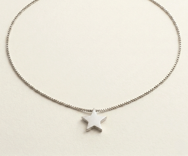 El Collar Estrella Minimal Silver es una joya de elegancia pura y moderna. Presenta un dije de estrella sólida con acabado pulido espejo que se desliza delicadamente sobre una sofisticada cadena tipo serpiente. Fabricado en acero quirúrgico de alta calidad, es una pieza atemporal y resistente, diseñada para capturar la luz con un estilo sutil y sofisticado.