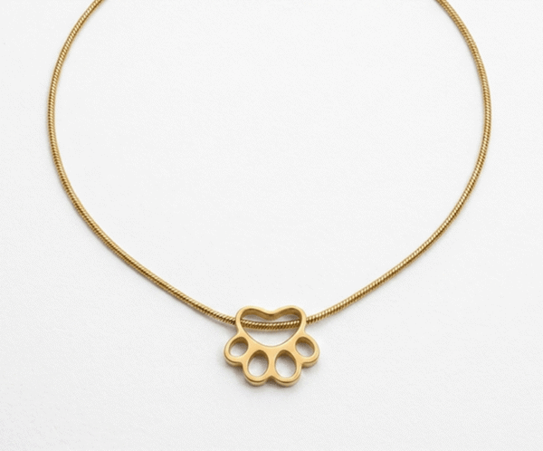 El Collar Huella Minimalista Golden es el tributo perfecto al amor incondicional por nuestras mascotas. Presenta un delicado dije calado en forma de huella que desliza sobre una sofisticada cadena tipo serpiente. Fabricado en acero quirúrgico con acabado en oro PVD, combina un diseño emocional con una durabilidad excepcional, ideal para el uso diario.