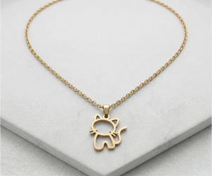 El Collar Michi Minimal Dorado es una joya terna y minimalista con un radiante acabado dorado. Destaca por su encantador dije calado con la silueta de un pequeño gato sentado, detallando sus bigotes y una graciosa cola curvada. Fabricado en acero quirúrgico, es el accesorio perfecto para amantes de los animales.