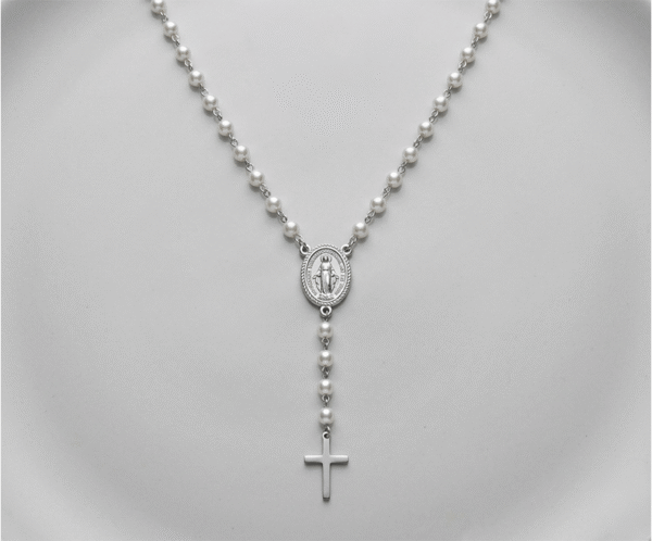 El Collar Rosario Perlas & Silver es una joya mística que fusiona espiritualidad y elegancia contemporánea con un impecable acabado plateado. Destaca por su delicada cadena intercalada con perlas blancas brillantes, que fluyen hacia una medalla central ovalada y una cruz pulida. Fabricado en acero quirúrgico, es un amuleto sofisticado y duradero.