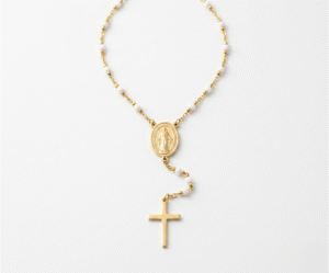 El Collar Rosario White & Gold es una joya mística que fusiona espiritualidad y elegancia contemporánea con un radiante acabado dorado. Destaca por su delicada cadena intercalada con cuentas blancas puras, que fluyen hacia una medalla central ovalada y una cruz pulida. Fabricado en acero quirúrgico, es un amuleto sofisticado y duradero.