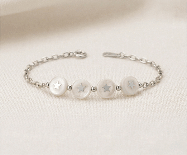 La Pulsera Círculos Nacarados es una joya de elegancia atemporal y brillo orgánico con un acabado plateado impecable. Destaca por sus cuatro medallones circulares de nácar natural que incluyen estrellas plateadas en su centro, unidos por una refinada cadena de eslabones. Fabricada en acero quirúrgico, combina sofisticación y luz con un estilo único.