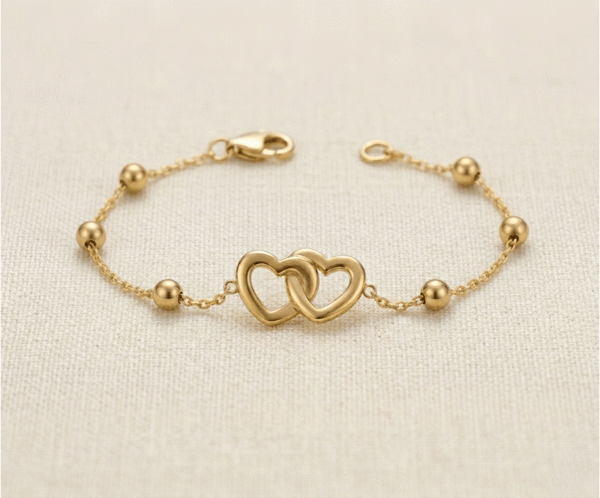 La Pulsera Corazones Entrelazados es una joya llena de significado y elegancia. Presenta un dije central de dos corazones calados íntimamente unidos, acompañados por delicadas esferas pulidas en una cadena de eslabones dorados. Fabricada en acero quirúrgico, es el accesorio perfecto para simbolizar la unión eterna con un estilo sofisticado y atemporal.