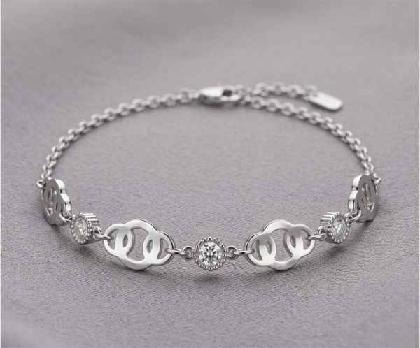 La Pulsera Corona de Brillos es una joya de elegancia majestuosa con un impecable acabado plateado. Presenta una secuencia de eslabones calados con formas curvas, intercalados con cristales solitarios engastados en biseles perlados que capturan la luz intensamente. Fabricada en acero quirúrgico, es la pieza ideal para un estilo sofisticado y atemporal.