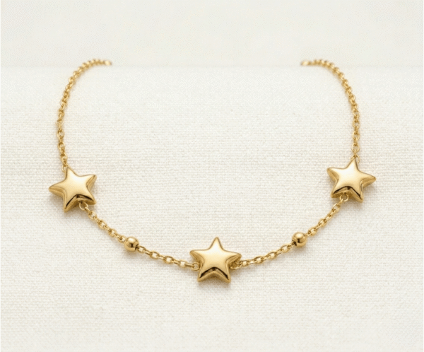La Pulsera Estrella Fugaz es una pieza mágica que captura la esencia del cosmos. Presenta tres estrellas de cinco puntas con relieve suave, intercaladas con delicadas esferas pulidas en una cadena de eslabones finos. Fabricada en acero quirúrgico con un lujoso baño dorado, es una joya radiante y resistente que simboliza sueños y deseos.