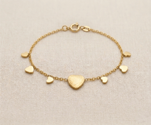 La Pulsera Lluvia de Corazones es una pieza de exquisita delicadeza y encanto romántico. Presenta un corazón central de mayor tamaño con una textura martillada artesanal, rodeado por pequeños dijes de corazones lisos que parecen caer en cascada sobre una fina cadena dorada. Fabricada en acero quirúrgico, es el accesorio perfecto para un estilo femenino y dulce.