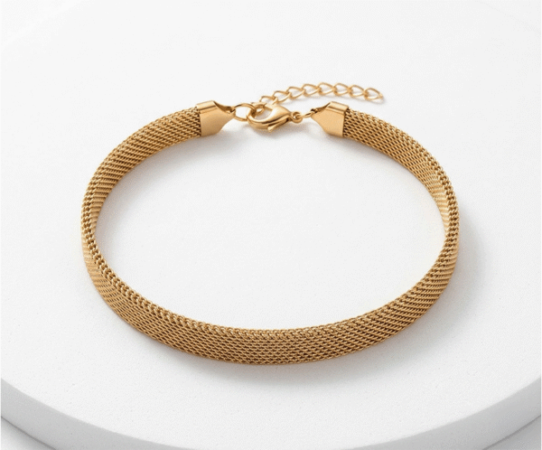 Pulsera Malla Gold _A160 La Pulsera Malla Gold es una joya sofisticada de diseño plano y tubular con un deslumbrante acabado dorado brillante. Destaca por su elegante tejido de malla flexible, que imita una textura sedosa muy favorecedora. Fabricada en acero quirúrgico, incorpora un cierre de mosquetón con cadena ajustable para un calce perfecto.
