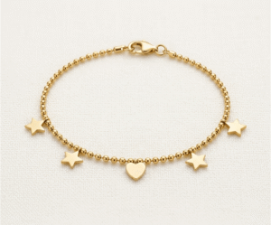 La Pulsera Mix Galáctico es una joya celestial y moderna que destaca por su diseño de cuentas esféricas pulidas. Presenta un conjunto armonioso de cuatro estrellas y un corazón central liso, todos con un acabado dorado brillante. Fabricada en acero quirúrgico, es un accesorio versátil y duradero que aporta un toque místico y sofisticado.