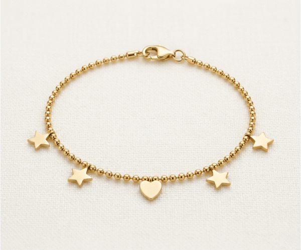 La Pulsera Mix Galáctico es una joya celestial y moderna que destaca por su diseño de cuentas esféricas pulidas. Presenta un conjunto armonioso de cuatro estrellas y un corazón central liso, todos con un acabado dorado brillante. Fabricada en acero quirúrgico, es un accesorio versátil y duradero que aporta un toque místico y sofisticado.
