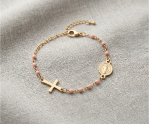 La Pulsera Rosario Pink & Gold es una delicada pieza que fusiona devoción y tendencia con un deslumbrante acabado dorado. Destaca por su fina cadena intercalada con tiernas cuentas rosa pastel, que incorporan una medalla circular de la Virgen y una cruz horizontal integrada. Fabricada en acero quirúrgico, es un amuleto ajustable y sofisticado.