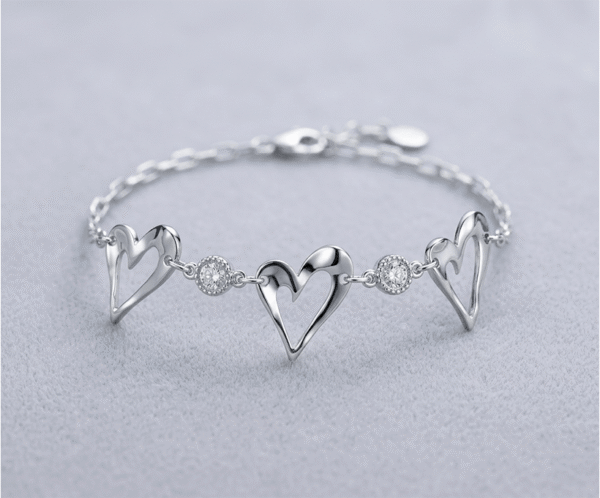 La Pulsera Triple Corazón es una joya que destila romance y modernidad. Presenta tres elegantes siluetas de corazones calados con acabado pulido, intercalados con brillantes cristales engastados que capturan la luz. Fabricada en acero quirúrgico de alta calidad, es una pieza sofisticada y resistente, ideal para simbolizar vínculos especiales con un estilo ligero y refinado.
